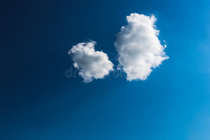 Cielo blu con un primo piano bianco di due nuvole fotografia stock libera da diritti Cielo blu con un primo piano bianco di due nuvole fotografia stock libera da diritti