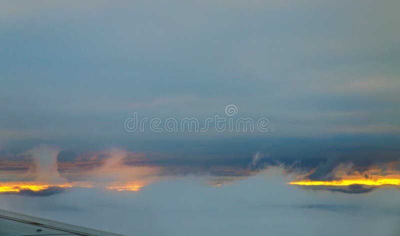 Cielo hermoso de la puesta del sol sobre las nubes con la visión dramática desde el aeroplano fotografía de archivo Cielo hermoso de la puesta del sol sobre las nubes con la visión dramática desde el aeroplano fotografía de archivo