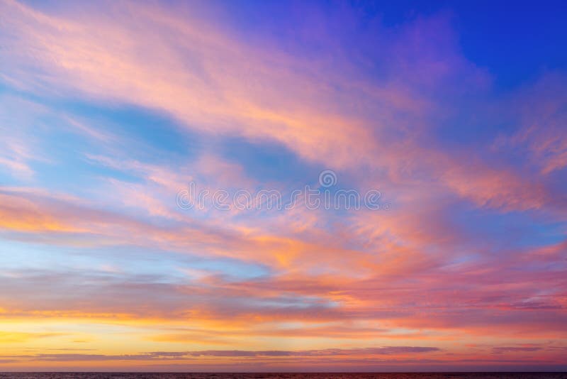 Cielo hermoso de la tarde con las nubes rosadas Puesta del sol sobre el mar