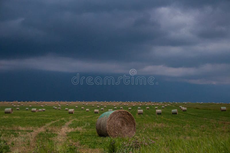 Cielo minaccioso con le balle di fieno fotografia stock Cielo minaccioso con le balle di fieno fotografia stock