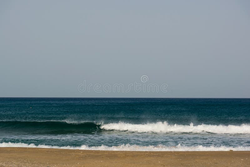 Cielo nublado, viento y ondas en una playa arenosa del mar imagen de archivo Cielo nublado, viento y ondas en una playa arenosa del mar imagen de archivo