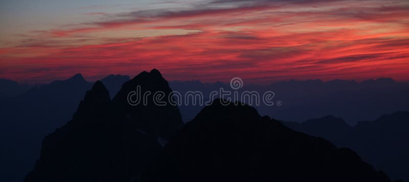 Cielo rojo de la tarde sobre las montañas suizas imagen de archivo Cielo rojo de la tarde sobre las montañas suizas imagen de archivo