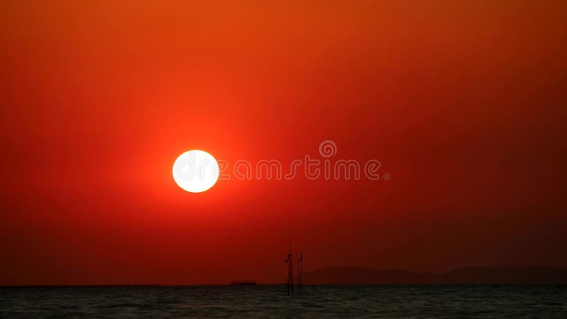 Cielo rosso tramonto sulla nuvola in mare e su un peschereccio che passa per il tempo.