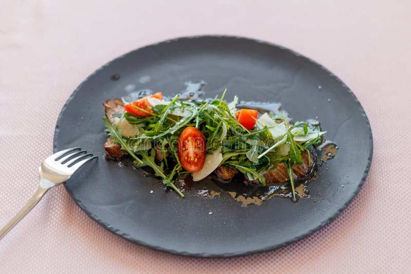 Cielęcina stku sałatka z arugula, sałata, przekrawa czereśniowych pomidory, Parmezański ser obrazy royalty free Cielęcina stku sałatka z arugula, sałata, przekrawa czereśniowych pomidory, Parmezański ser obrazy royalty free