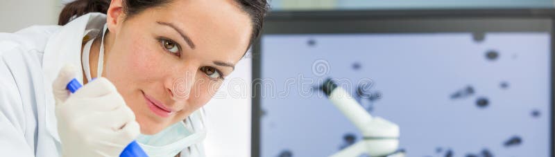 Cient?fico de sexo femenino With Pipette de la investigaci?n y frasco en laboratorio foto de archivo Cient?fico de sexo femenino With Pipette de la investigaci?n y frasco en laboratorio foto de archivo