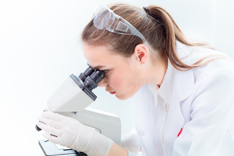 Cientista bonito que trabalha no microscópio no laboratório médico imagens de stock
