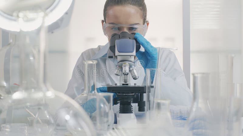 Científica trabajando con un microscopio imagen de archivo