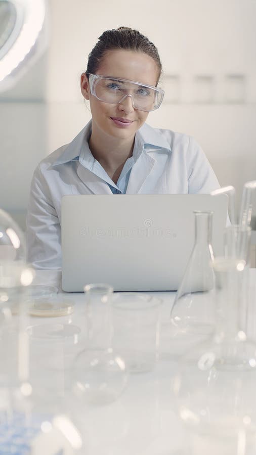 Científica trabajando en un portátil en el laboratorio fotos de archivo