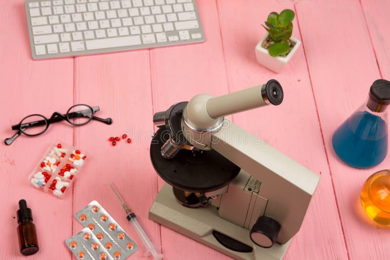 Científico del lugar de trabajo/doctor - microscopio, píldoras, jeringuilla, lentes, frascos químicos con el líquido en la tabla imagenes de archivo Científico del lugar de trabajo/doctor - microscopio, píldoras, jeringuilla, lentes, frascos químicos con el líquido en la tabla imagenes de archivo