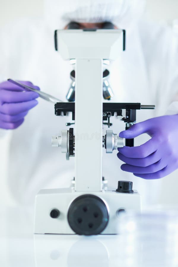 Científico forense con el microscopio fotografía de archivo Científico forense con el microscopio fotografía de archivo
