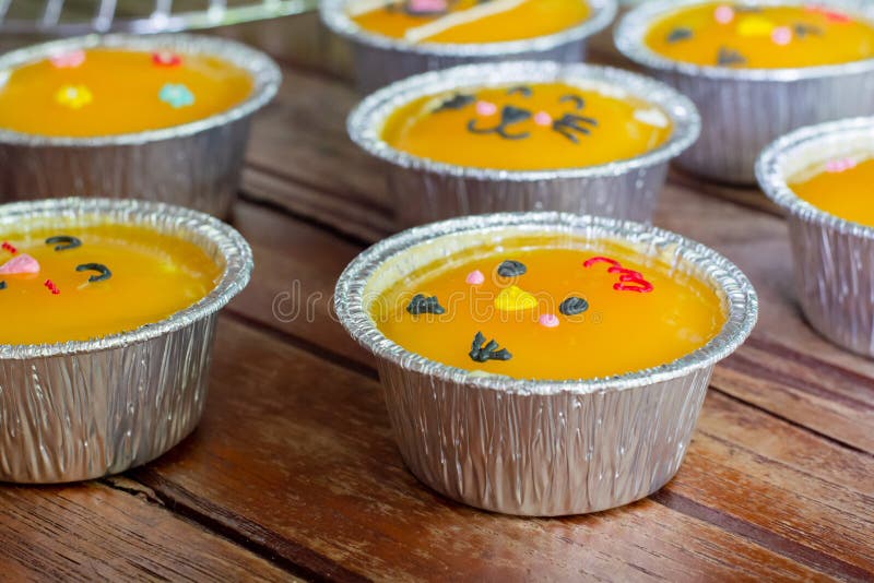 Cierra un pastel mÃnimo de naranja con crema de mantequilla en una taza de papel sobre una mesa de madera. Deliciosa panaderÃa e foto de archivo Cierra un pastel mÃnimo de naranja con crema de mantequilla en una taza de papel sobre una mesa de madera. Deliciosa panaderÃa e foto de archivo