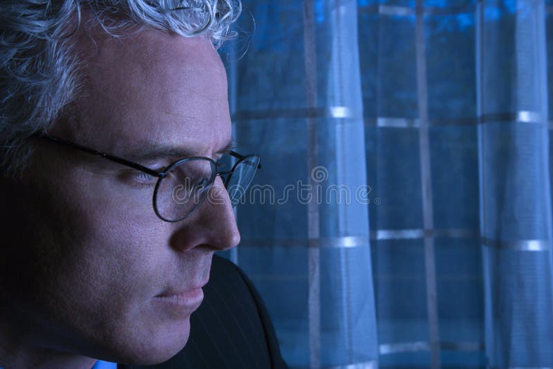 Blue tone close up profile of prime adult Caucasian man in suit. Blue tone close up profile of prime adult Caucasian man in suit.