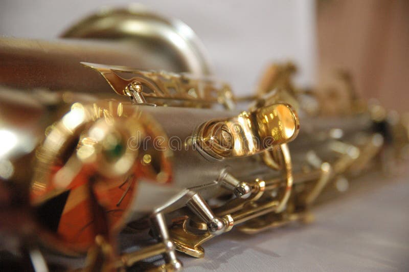 Cierre clásico del color oro del saxofón del instrumento musical encima de la textura del detalle imágenes de archivo libres de regalías Cierre clásico del color oro del saxofón del instrumento musical encima de la textura del detalle imágenes de archivo libres de regalías