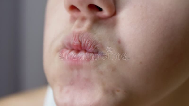 Cierre de la cara de un niño nervioso mordiendo los labios con los dientes. macro