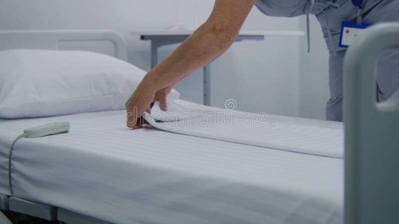 Cierre de las camas con cambios de enfermería madura en la sala de hospital almacen de metraje de vídeo