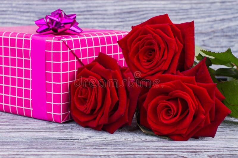 Cierre de las rosas rojas y de la caja de regalo para arriba foto de archivo libre de regalías Cierre de las rosas rojas y de la caja de regalo para arriba foto de archivo libre de regalías