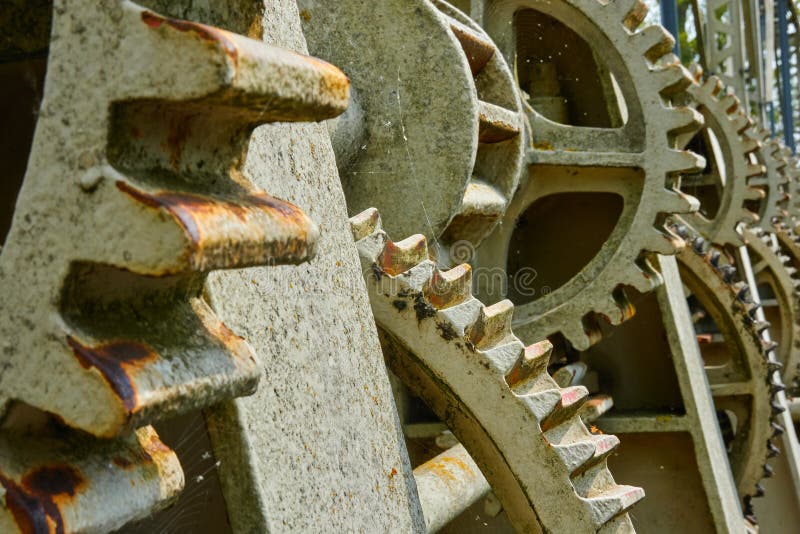 Close-up of the cogwheels of a historical weir of a river to regulate the spear wall of the weir. Close-up of the cogwheels of a historical weir of a river to regulate the spear wall of the weir.