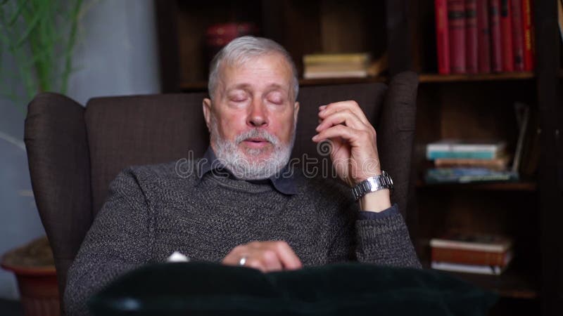 Cierre de un hombre triste y deprimido que cuenta una triste historia mientras se sienta en un cómodo sillón. metrajes