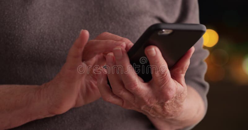 Cierre de una mujer madura usando un smartphone para leer mensajes en el fondo de bokeh almacen de video