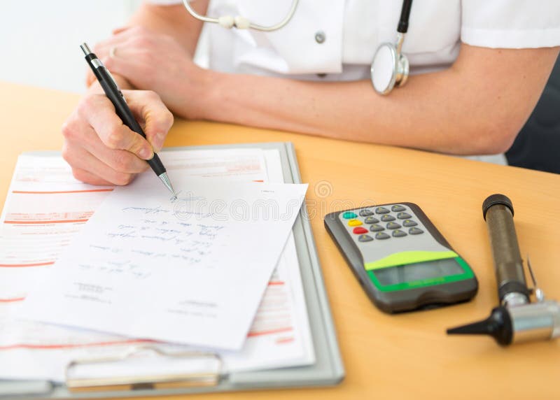 Cierre encima de viewof a un doctor que llena una prescripción a un paciente imágenes de archivo libres de regalías Cierre encima de viewof a un doctor que llena una prescripción a un paciente imágenes de archivo libres de regalías