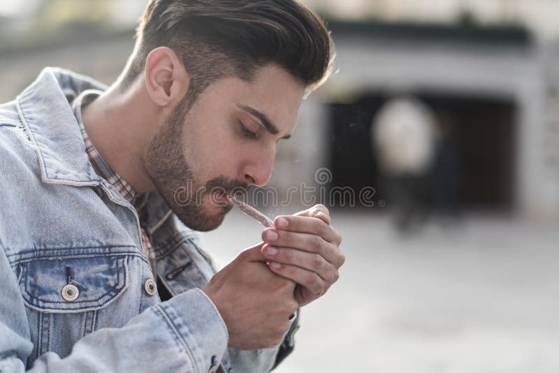 Cigare de tabagisme de jeune homme frais image libre de droits Cigare de tabagisme de jeune homme frais image libre de droits