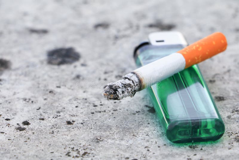 Cigarette Burn and Lighter on Floor Concrete Background. Concept Non