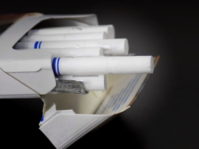Cigarettes with White Filter Paper. Closeup on a Dark Background