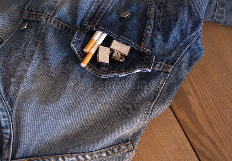 Necessary things for a man, maybe an old date. cigarettes, denim shirt, on a wooden table. Necessary things for a man, maybe an old date. cigarettes, denim shirt, on a wooden table