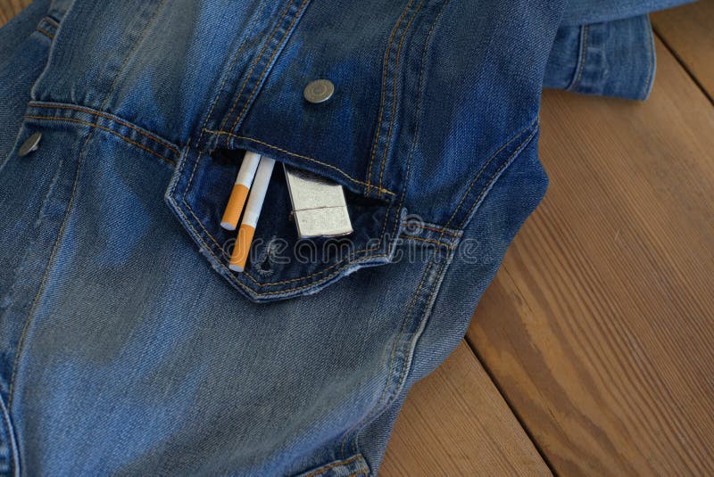 Necessary things for a man, maybe an old date. cigarettes, denim shirt, on a wooden table. Necessary things for a man, maybe an old date. cigarettes, denim shirt, on a wooden table