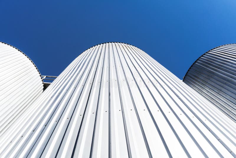 Cilindros de la fábrica de la bebida Con el cielo azul fotografía de archivo libre de regalías Cilindros de la fábrica de la bebida Con el cielo azul fotografía de archivo libre de regalías
