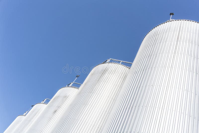 Cilindros de la fábrica de la bebida Con el cielo azul imagenes de archivo Cilindros de la fábrica de la bebida Con el cielo azul imagenes de archivo