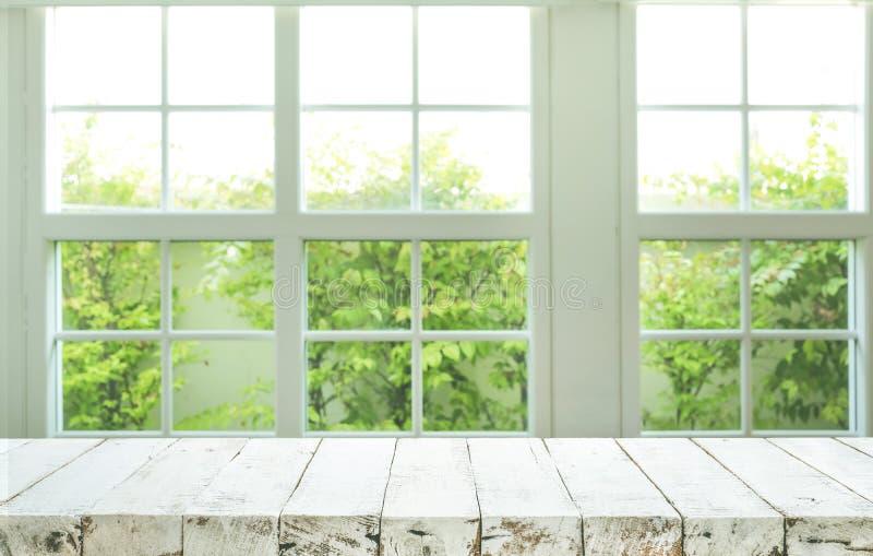 Cima del contatore di legno della tavola sul fondo del giardino di vista della finestra della sfuocatura