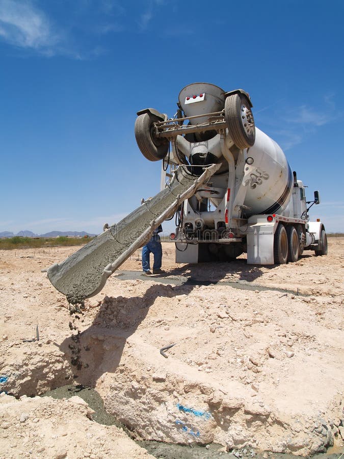 A cement truck is pouring cement into a foundation. Vertically framed shot. A cement truck is pouring cement into a foundation. Vertically framed shot.