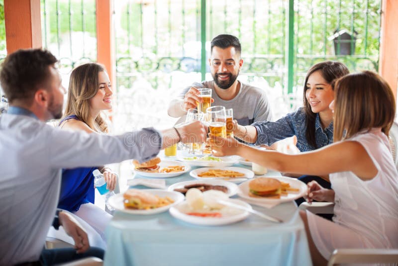 Cinco amigos que hacen la tostada en una barbacoa imágenes de archivo libres de regalías Cinco amigos que hacen la tostada en una barbacoa imágenes de archivo libres de regalías