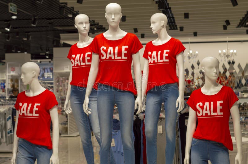 Cinco manequins em seguido vestidos nas calças de brim e em t-shirt vermelhos com as palavras ‘VENDA ‘ fotografia de stock royalty free Cinco manequins em seguido vestidos nas calças de brim e em t-shirt vermelhos com as palavras ‘VENDA ‘ fotografia de stock royalty free