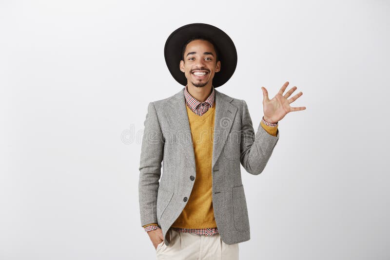 Cinco maneras a la felicidad Modelo masculino de piel morena alegre apuesto en sombrero negro de moda y el aumento elegante del e fotos de archivo Cinco maneras a la felicidad Modelo masculino de piel morena alegre apuesto en sombrero negro de moda y el aumento elegante del e fotos de archivo