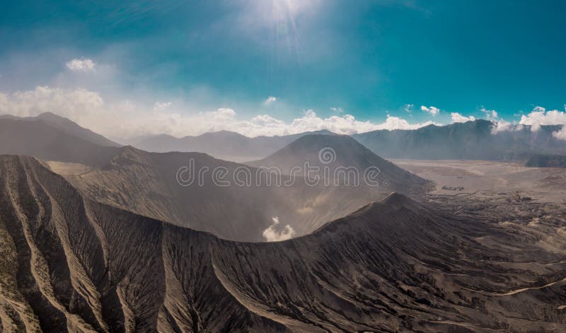 Cinematic shot aerial view of Mount Bromo crater with active volcano smoke in East Java