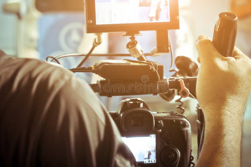 Cineoperatore con la sua fucilazione della videocamera fotografia stock Cineoperatore con la sua fucilazione della videocamera fotografia stock