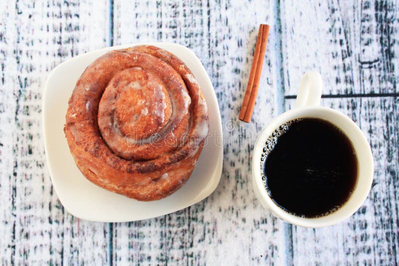 Cinnamon bun with coffee stock image. Image of treat 81942059