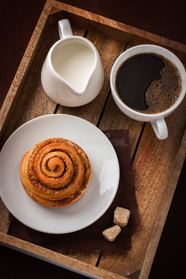 Cinnamon Roll, Cup of Coffee and Cream on Wooden Tray Stock Image