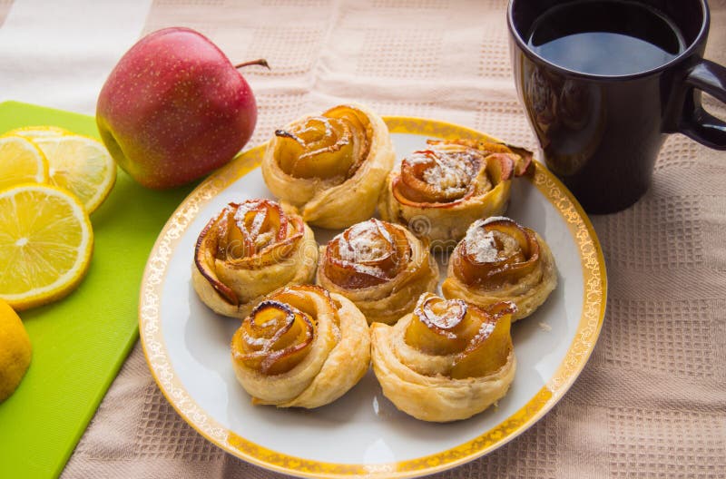 Cinnamon Rolls, Apple on the Plate. Tea Cup and Lemon Stock Photo