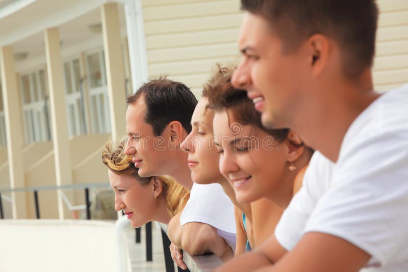 Cinq amis de sourire sur le balcon image libre de droits Cinq amis de sourire sur le balcon image libre de droits