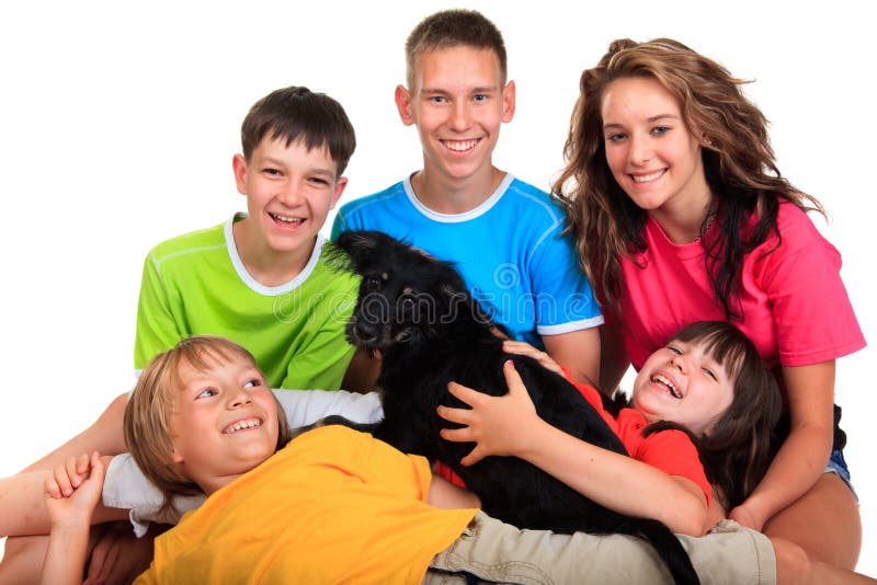 Five happy siblings in colorful tee shirts holding a black pet dog isolated against a white background. Five happy siblings in colorful tee shirts holding a black pet dog isolated against a white background.