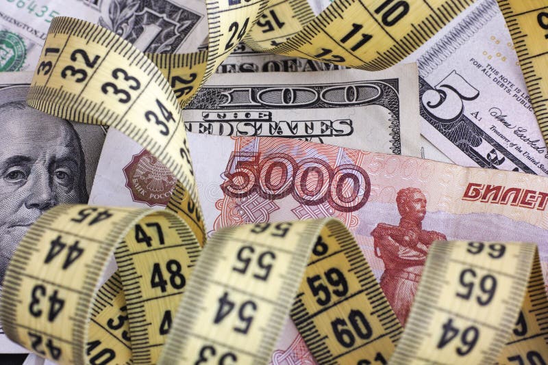 Cinq mille roubles avec le ruban métrique sur des billets de banque du dollar photographie stock Cinq mille roubles avec le ruban métrique sur des billets de banque du dollar photographie stock