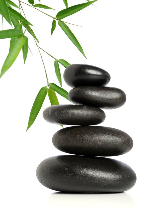 Five black stones balanced with bamboo leaves in background. Five black stones balanced with bamboo leaves in background