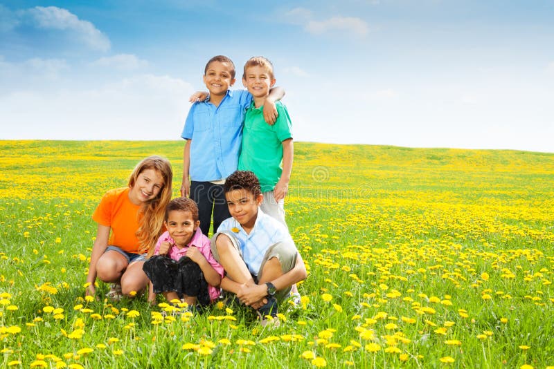 Cinque bambini felici in denti di leone immagine stock libera da diritti Cinque bambini felici in denti di leone immagine stock libera da diritti