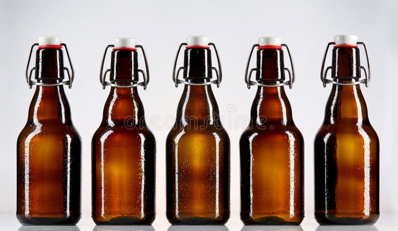 Cinque bottiglie di vetro in bianco di birra immagine stock Cinque bottiglie di vetro in bianco di birra immagine stock
