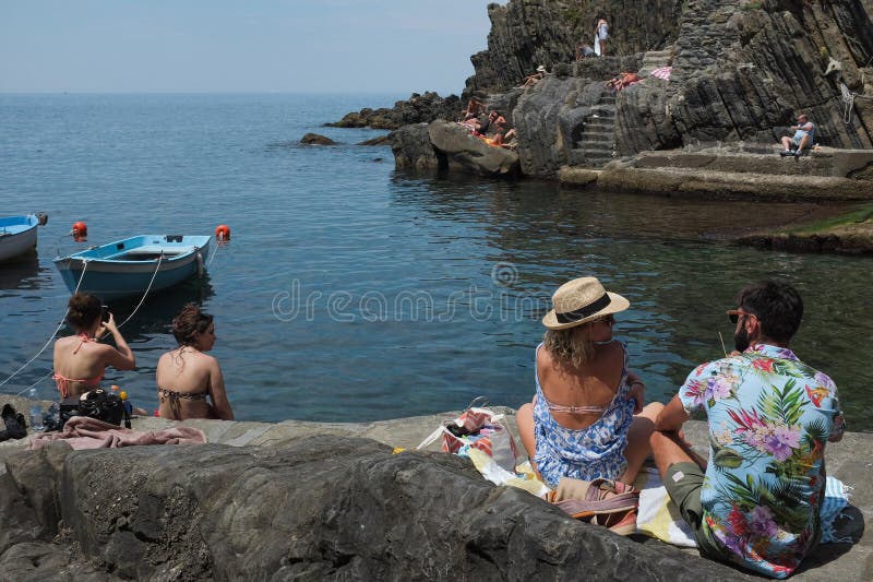 Cinque terre - turisti italiani in costume da bagno al riomaggiore dock. città costiera della riviera italiana. gente su rocky Bea immagini stock libere da diritti