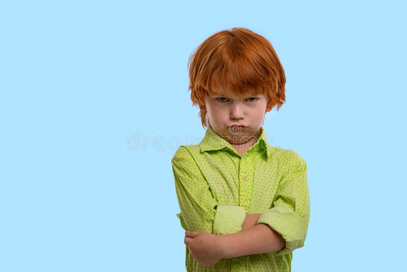 Cintura encima del retrato emocional del muchacho del pelirrojo que lleva la camisa verde en un fondo azul en el estudio Hola los foto de archivo libre de regalías Cintura encima del retrato emocional del muchacho del pelirrojo que lleva la camisa verde en un fondo azul en el estudio Hola los foto de archivo libre de regalías