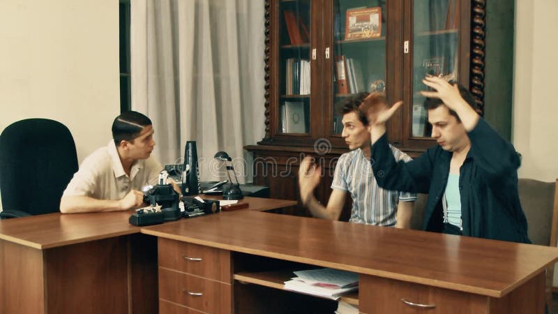 Cinéaste dans discuter fâché de filet de cheveux avec des travailleurs de bureau au sujet du scénario